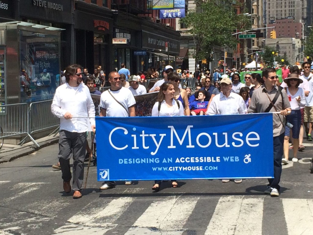 CityMouse employees marching in the parade, carrying a banner that says CityMouse.