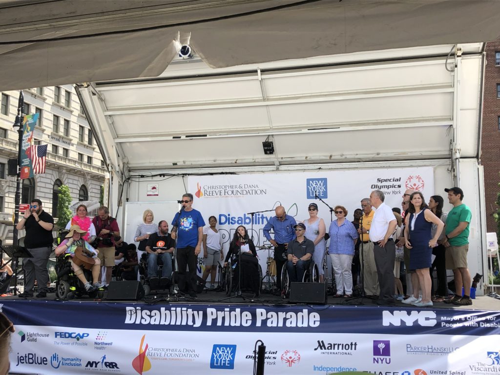 Image of the 2019 Disability Pride NYC Parade main stage depicting event organizers and VIP's. 