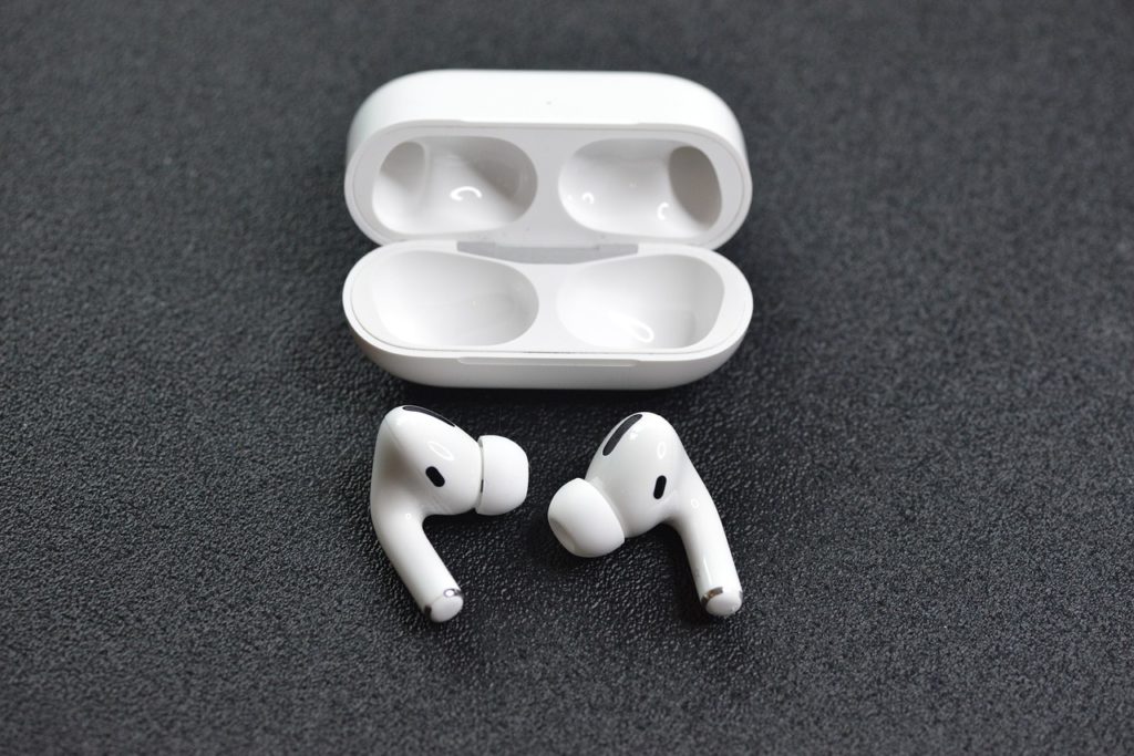 Open AirPod case with two AirPods next to it