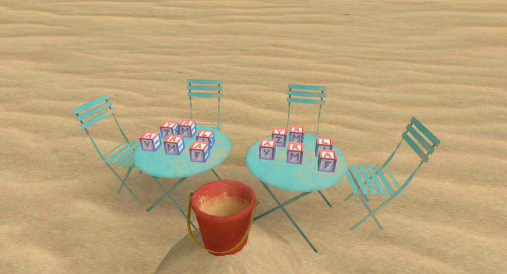 On a beach with four chairs around two tables. The tables contain blocks with letters on their sides.